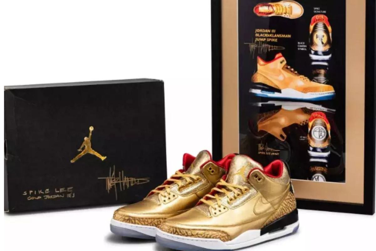 Paire de baskets Jordan III dorées en édition limitée avec packaging noir et affiche commémorative