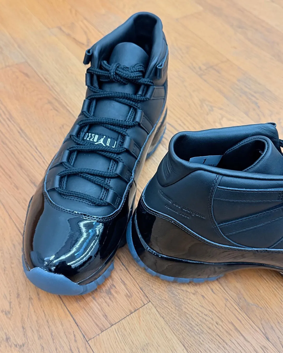 Détail de la Air Jordan 11 Comme des Garçons noire, Jumpman embossé sur le talon